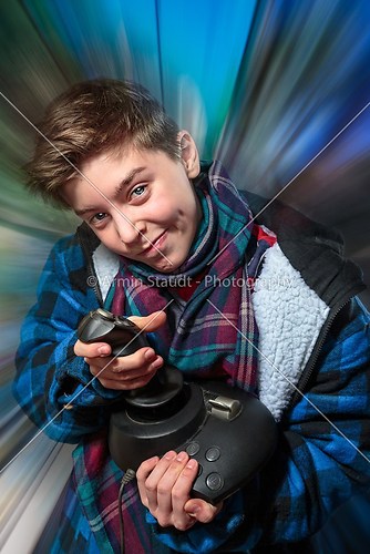 concentrated teenage boy with joy-stick with motion blur backgro