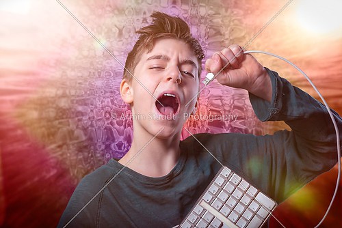 singing teenage boy with computer keyboard and spacy background