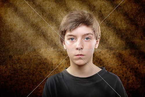 portrait of a teenage boy with scary brown background