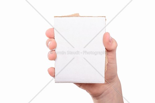 one hand holding a white piece of cardboard