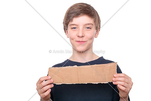 portrait of a teenage boy holding a brown piece of cardboard in 