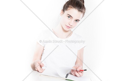 teenager school girl  browsing in a blank diary, isolated on whi