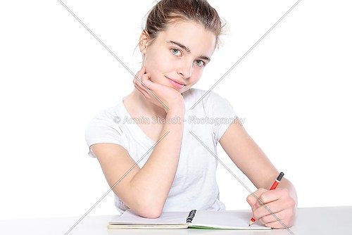 sitting female teenager with open empty book and pencil, isolate