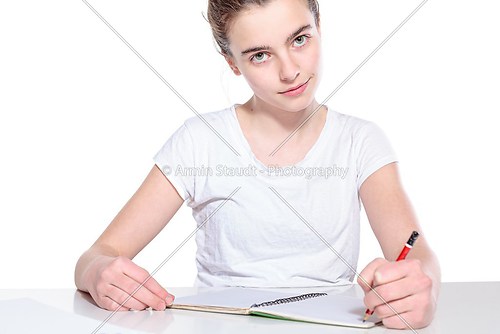 smiling teenage girl with copy book and pencil, isolated on whit