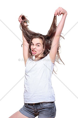 stressed teenage girl pulling her hair out, isolated on white