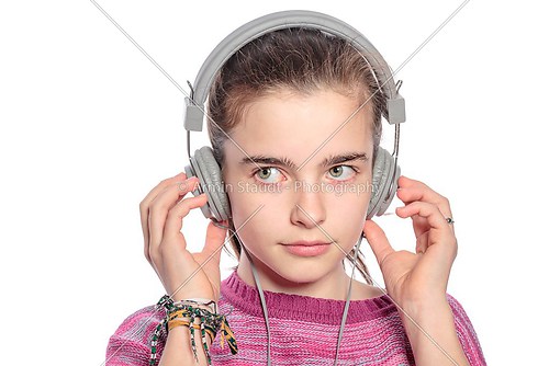 female teenager with headphones hearing music, isolated on white