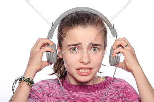 scared teenager girl with headphones,  isolated on white