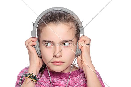 teenage girl hears something scary on headphones, isolated on wh