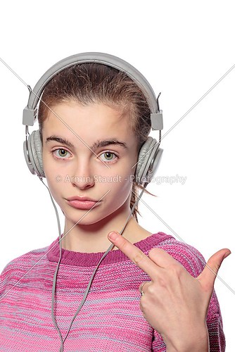cool teenage girl with headphones giving middle finger, isolated