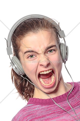 keen  shouting female teenager with headphones, isolated on whit