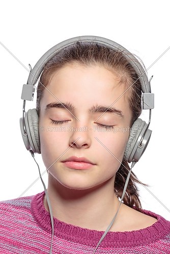 female teenager with earphones and closed eyes hears music, isol