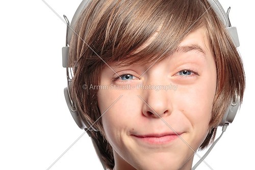 male teenager with headphones hurts the music, isolated on white