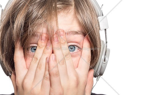 desperate male teenager with headphones covering his face with h