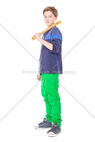 happy teenage boy holding a flute on his shoulder, isolated on w