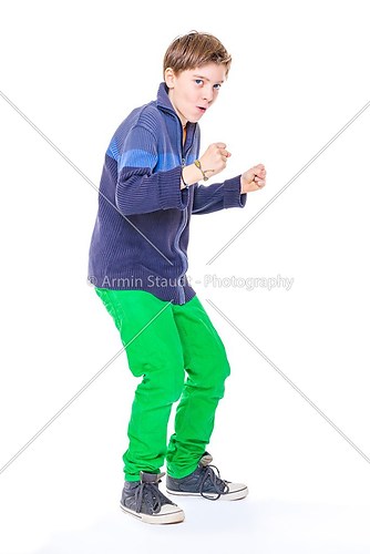 casual cool teenage boy clenches his fists, isolated on white