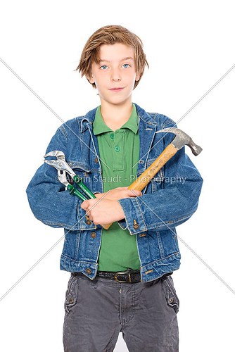 smiling teenage boy holding a hammer and pliers, isolated on whi