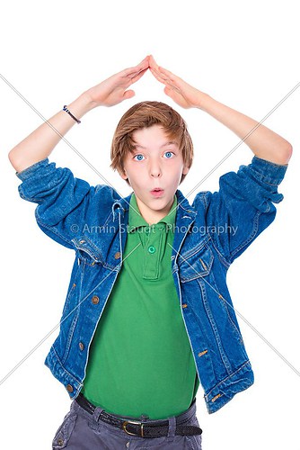 amazed teenage boy forms a roof over his head with his two arms,