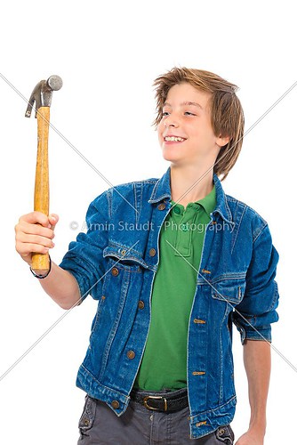 confident teenage boy smiling to a hammer in his hand, isolated 