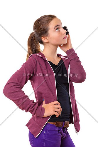 teenage girl speaking on mobile phone, looking into the sky, iso