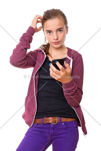 confused beautiful teenage girl with mobile phone, , isolated on