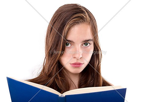 portrait of a teenage girl reading a book isolated on white