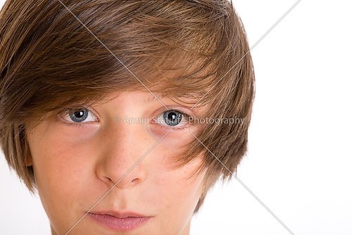 Closeup of a cute teenage boy smiling into the camera, isolated 