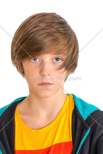 Closeup of a cute teenage boy looking into the camera, isolated 