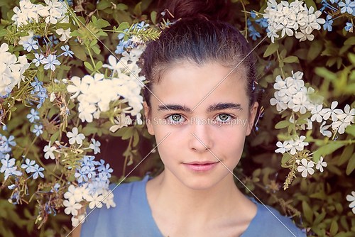 portrait of a beautiful teenage girl in a blooming bush