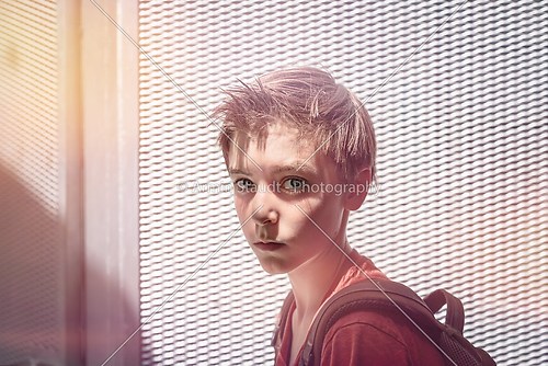 portrait of a teenager boy with rucksack and extreme light in fr