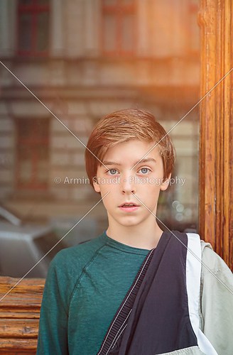 portrait of a teenager boy in front of a glass panel