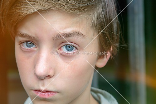 serious looking teenager boy in front of a metal grid