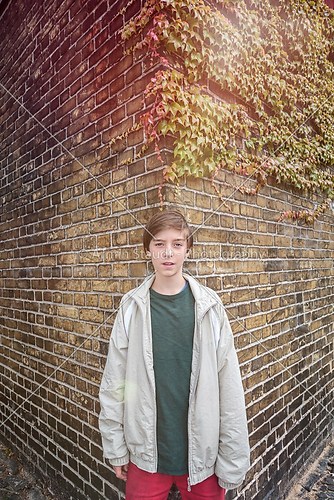 portrait of a teenager boy in front of an old brick wall