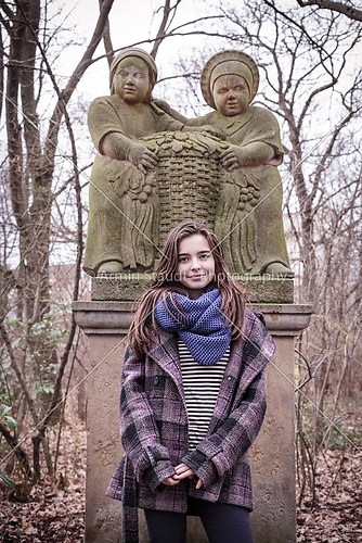 portrait of a beautiful female teenager in front of a sculpture 