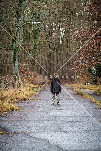 lonely boy standing on a street in winter