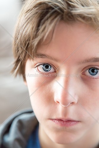 close up portrait of a male teenager with big blue eyes
