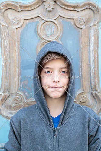 portrait of a male teenager in front of an old wooden door with 