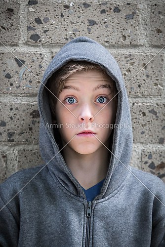 portrait of a male teenager with wide eyed in front of a wall