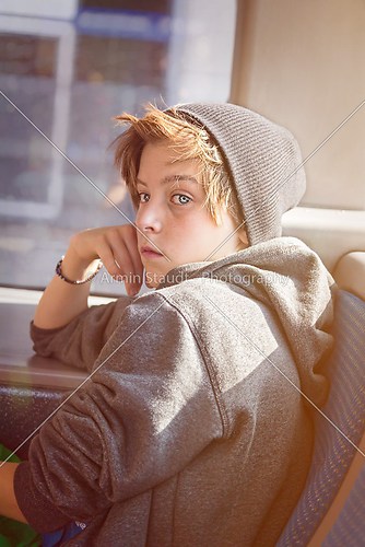 portrait of a teenager boy with toque, sitting in a bus