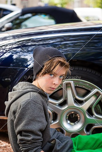 cool teenage boy sitting in front of a rim of wheel