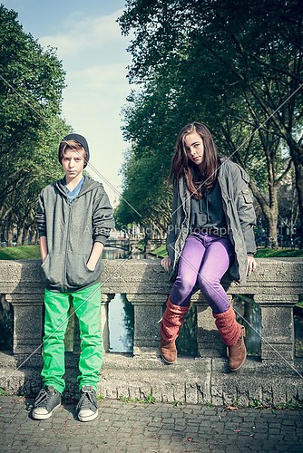 vintage style portrait of two teenager sitting on a bridge
