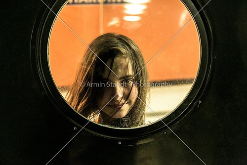 girl looking through a round window