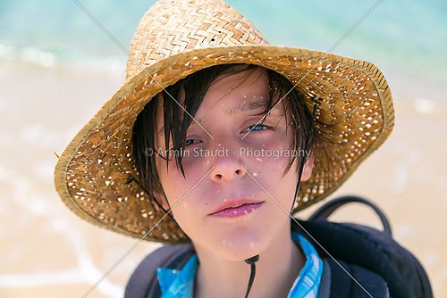 portrait of a boy with straw hat and rucksack 