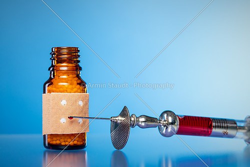 still life with homeopathy globules. syringe with blood and  pla