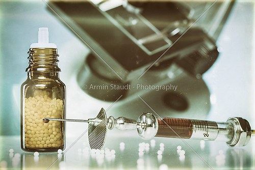 vintage still life with homeopathy globules, syringe with blood 