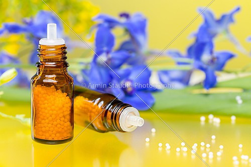 two bottleswith homeopathy globules and flowers, with yellow ref
