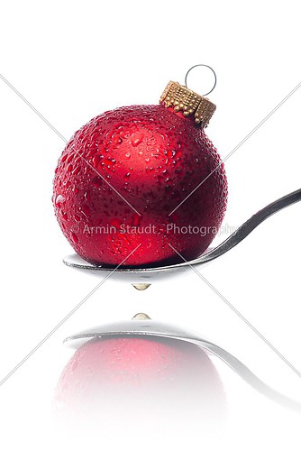 red christmas ball with water drops on a spoon
