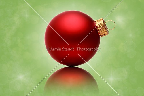 close up of a red christmas ball with green star background