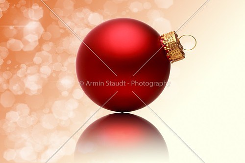 close up of a red christmas ball with blurred red background