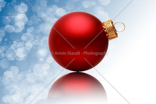 close up of a red christmas ball with blurred blue background