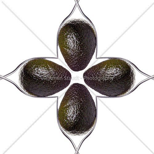 square of four avocados between two forks, isolated on white